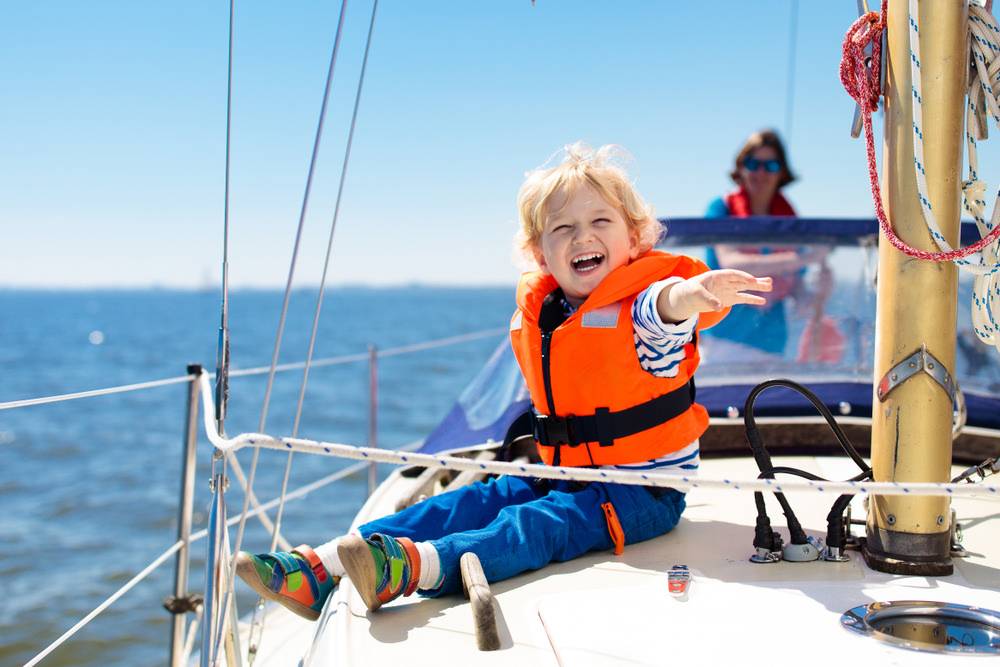 Little boy in safe life jackets travel on charter boat in key west, fl. 