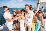 A young couple drinks champagne and enjoys a sailboat wedding with friends in Key West